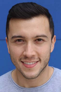 Mavi arka planda gülümseyen şirin etnik adam.