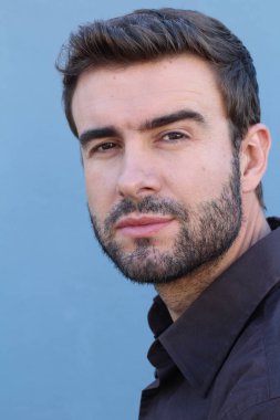 Duvarın önündeki yakışıklı sakallı adamın yakın plan portresi.