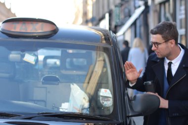 Sokakta taksiye binen yakışıklı genç adamın yakın plan portresi.