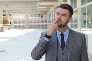 Sokakta gri takım elbiseli yakışıklı genç işadamının yakın plan portresi.