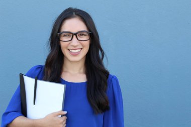 Güzel kız öğrenci gülümsüyor ve kameraya bakıyor.