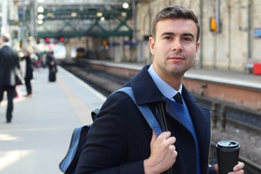 İş adamı retro tren istasyonunda yürüyor