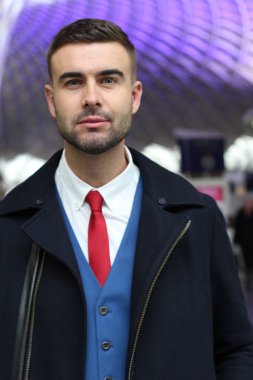 Takım elbiseli ve ceketli yakışıklı genç iş adamının yakın plan portresi.