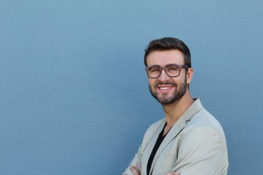 Duvarın önündeki yakışıklı sakallı adamın yakın plan portresi.