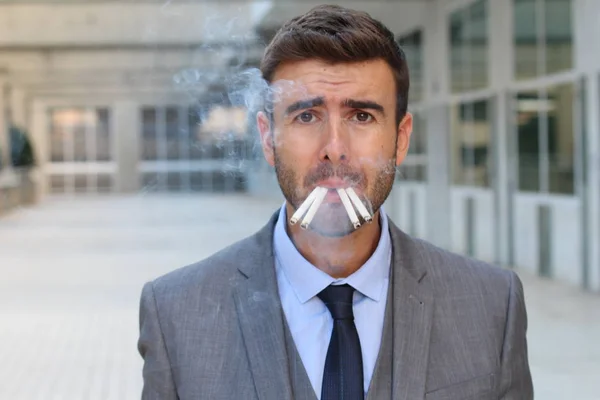 路上で多くのタバコを吸っているハンサムな若いビジネスマンの肖像画 — ストック写真
