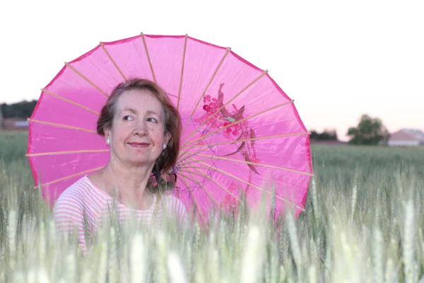 Volwassen Vrouw Met Een Roze Paraplu Tijdens Zonnige Dag — Stockfoto