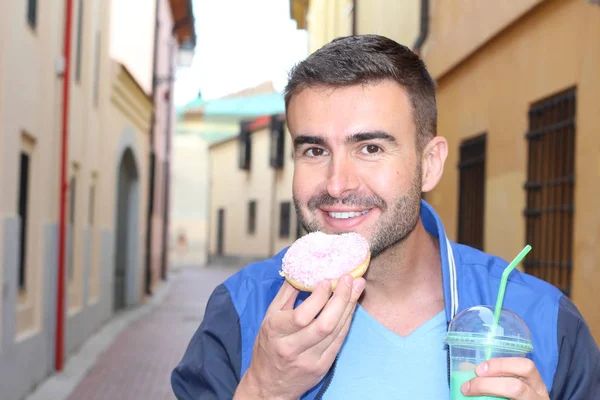 Άνθρωπος Τρώει Ένα Ντόνατ Και Πίνει Ένα Μιλκσέικ Έξω — Φωτογραφία Αρχείου
