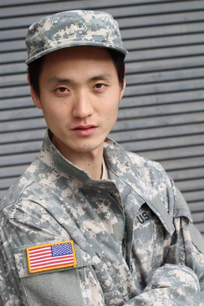 close-up portrait of handsome young asian soldier on street