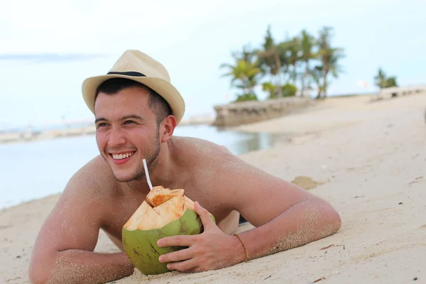 ビーチで新鮮なココナッツ水を飲む男 — ストック写真