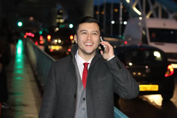 close-up portrait of handsome young businessman talking by phone on street of london