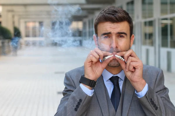 路上で多くのタバコを吸っているハンサムな若いビジネスマンの肖像画 — ストック写真