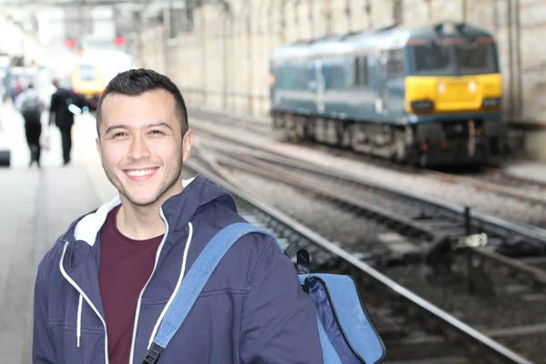 Cute ethnic young man in retro train station