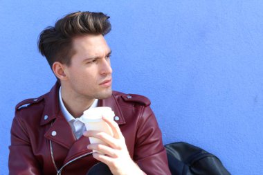 Rahatlamış modern bir adamın portresi açık havada oturmuş fotokopi alanı olan bir fincan çayla.