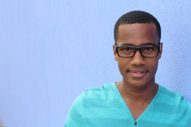 Yakışıklı, Afro-Amerikan, sıradan giyinmiş genç bir adamın yakın plan portresi.