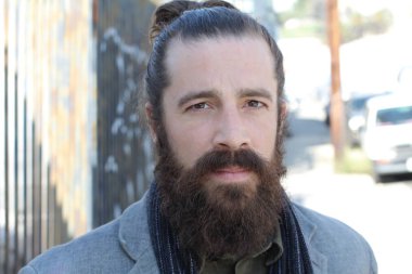 Tarz sahibi sakallı hippi modeli. Erkek saç stili, sokakta yaşam tarzı, tarlanın derinliği.