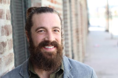 Tarz sahibi sakallı hippi modeli. Erkek saç stili, sokakta yaşam tarzı, tarlanın derinliği.