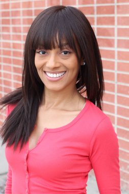 Closeup beauty portrait of young and attractive African American black woman with perfect skin, softly smiling. Health and beauty outdoors lifestyle