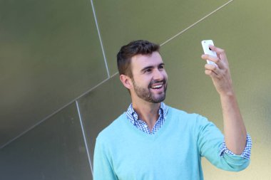 Kareli gömlekli genç bir adamın portresi ve telefonda konuşan Cyan süveteri. 