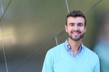 İşaretli gömlekli genç bir adam portresi ve kolları çapraz duran cyan süveter.