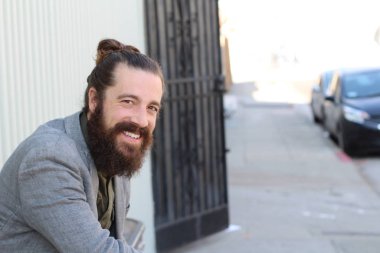 Tarz sahibi sakallı hippi modeli. Erkek saç stili, sokakta yaşam tarzı, tarlanın derinliği.