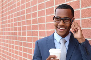 Yakışıklı Afro-Amerikan iş adamının yakın plan portresi tuğla duvarın önünde.