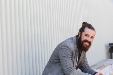 Tarz sahibi sakallı hippi modeli. Erkek saç stili, sokakta yaşam tarzı, tarlanın derinliği.