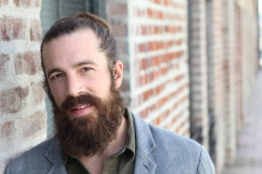 Tarz sahibi sakallı hippi modeli. Erkek saç stili, sokakta yaşam tarzı, tarlanın derinliği.