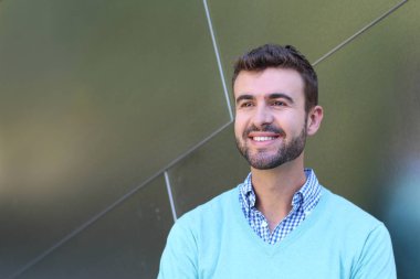 İşaretli gömlekli genç bir adam portresi ve kolları çapraz duran cyan süveter.