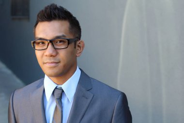 Portrait of young Asian man with glasses in office smiling