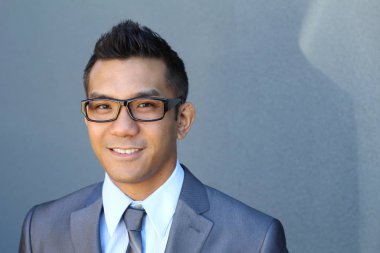 Portrait of young Asian man with glasses in office smiling