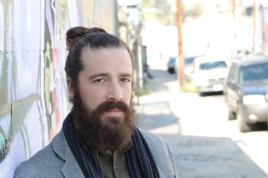 Tarz sahibi sakallı hippi modeli. Erkek saç stili, sokakta yaşam tarzı, tarlanın derinliği.