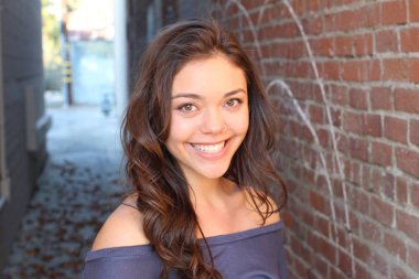 Açık havada duran melez üniversite öğrencisinin portresi.