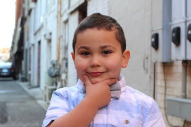 Açık havada, papyon takan şirin bir çocuğun portresi.