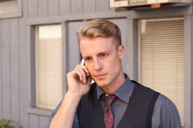 İngiliz centilmen güzellik konsepti. Dışarıda telefon kullanan genç ve yakışıklı bir adamın portresi. 