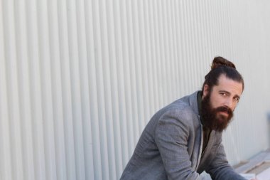 Tarz sahibi sakallı hippi modeli. Erkek saç stili, sokakta yaşam tarzı, tarlanın derinliği.