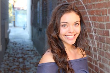 Açık havada duran melez üniversite öğrencisinin portresi.