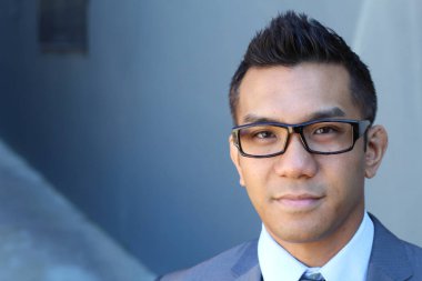Portrait of young Asian man with glasses in office smiling