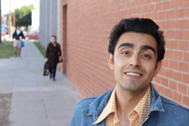 Kırmızı tuğla duvarın arka planında iyi bir adamın yakın plan portresi.