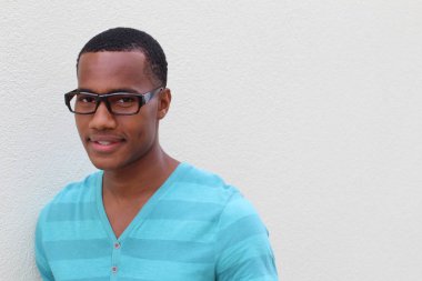 Yakışıklı, Afro-Amerikan, sıradan giyinmiş genç bir adamın yakın plan portresi.