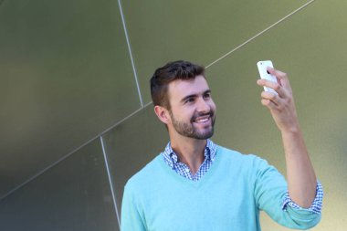 Kareli gömlekli genç bir adamın portresi ve telefonda konuşan Cyan süveteri. 