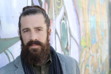 Tarz sahibi sakallı hippi modeli. Erkek saç stili, sokakta yaşam tarzı, tarlanın derinliği.