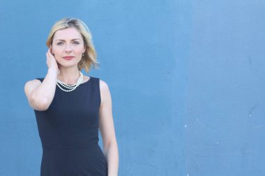 Şık, sarışın, sıradan saç stili ve akşam makyajlı bir kadının güzel portresi. İnci takan kadın