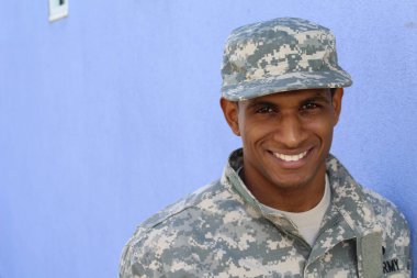 Mavi duvarın önünde üniformalı yakışıklı Afro-Amerikan askerinin yakın plan portresi