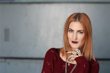 Parlak makyajlı, kızıl, pasaklı kadının stüdyo portresi. 