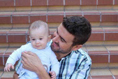 Merdivenlerde oturan melez aile yakınlaşması. Baba ve yeni doğan bebeğin portresi 