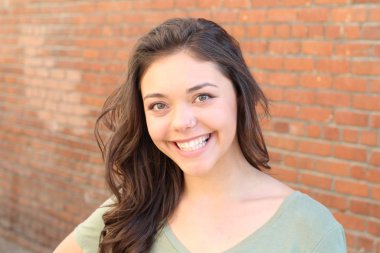 Portrait of beautiful female teenager on brick wall background 