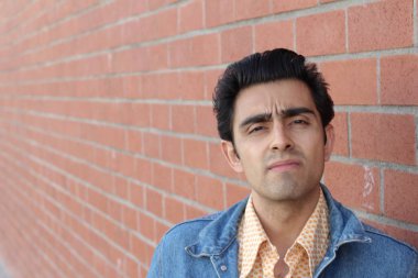 Kırmızı tuğla duvarın arka planında iyi bir adamın yakın plan portresi.