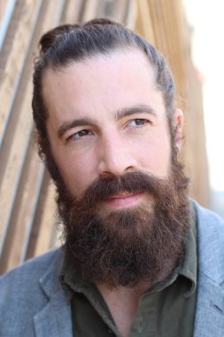 Tarz sahibi sakallı hippi modeli. Erkek saç stili, sokakta yaşam tarzı, tarlanın derinliği.