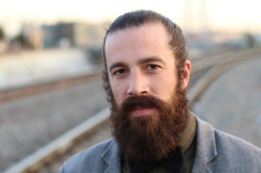 Tarz sahibi sakallı hippi modeli. Erkek saç stili, sokakta yaşam tarzı, tarlanın derinliği.