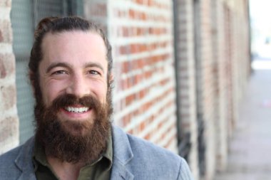 Tarz sahibi sakallı hippi modeli. Erkek saç stili, sokakta yaşam tarzı, tarlanın derinliği.